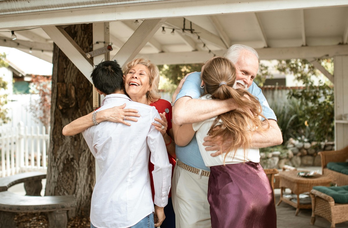 elderly couple embracing their family at an outdoor event