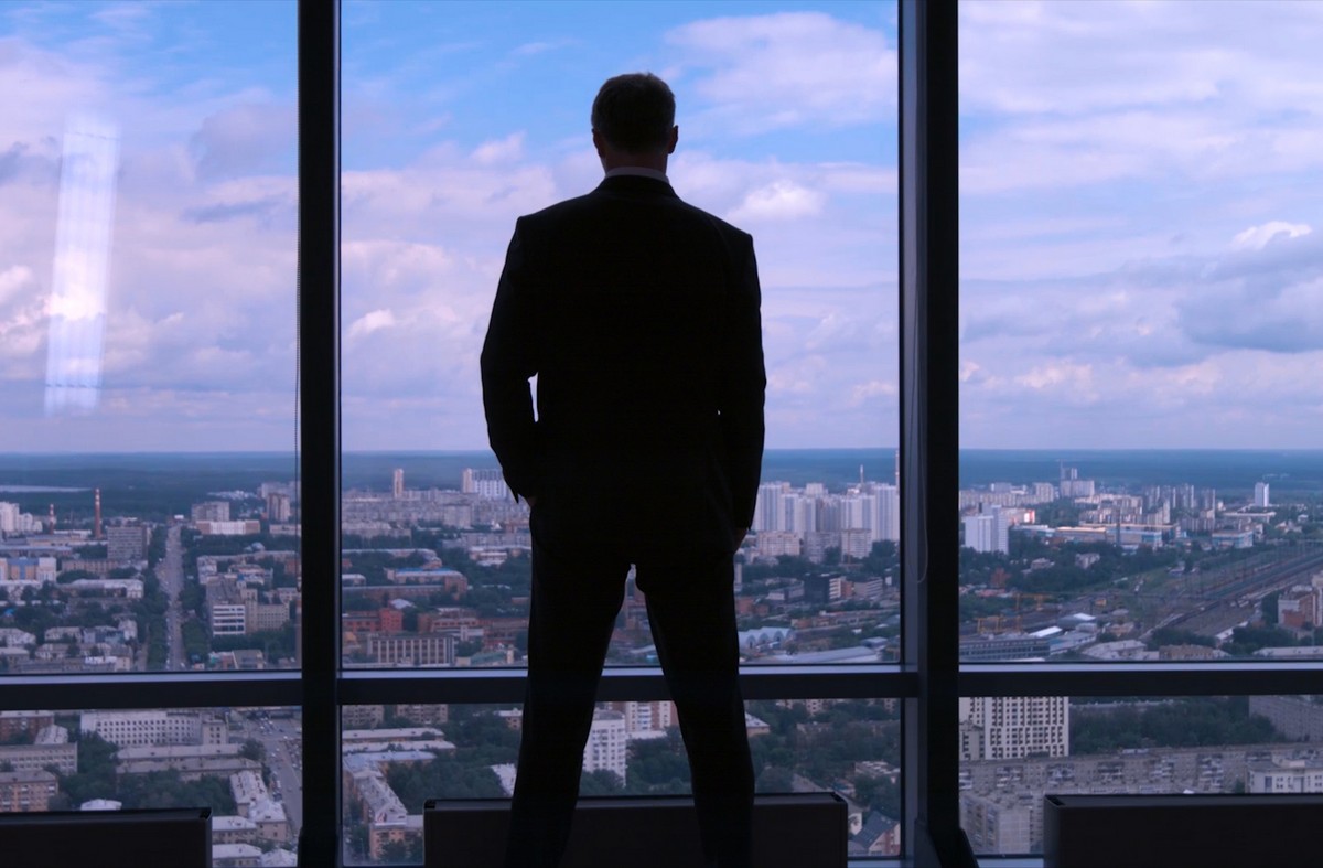 coli-info-hero business owner looking out his office through a glass window at the city